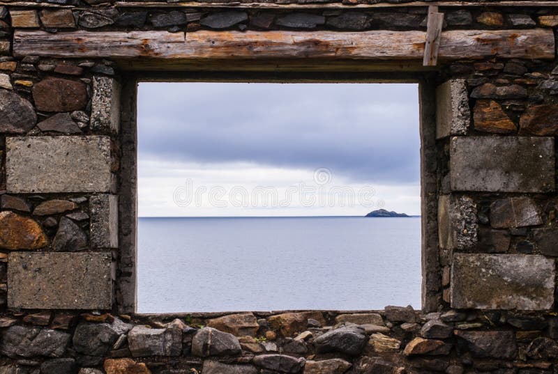 Sea view from a stone window of an old ruin near the ocean