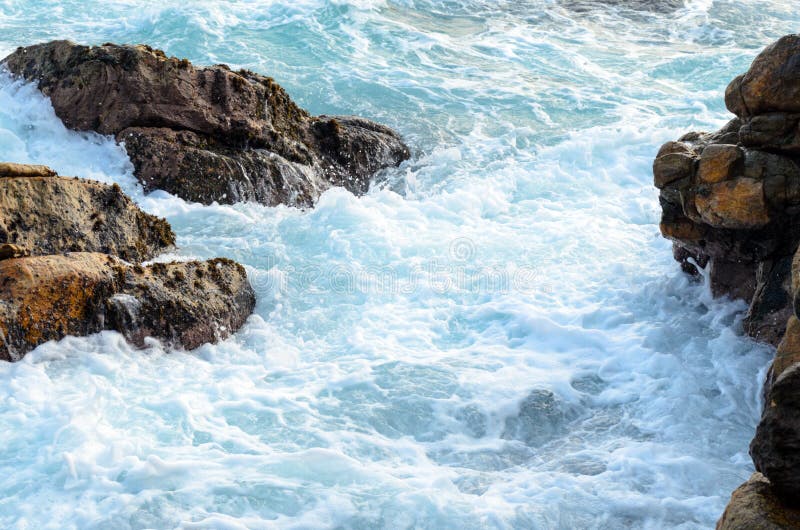 Foamy sea water flows through the stones royalty free stock photos