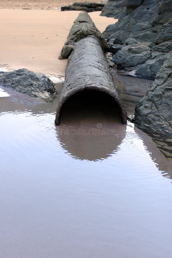 Sea water rusty overflow pipe stock photos