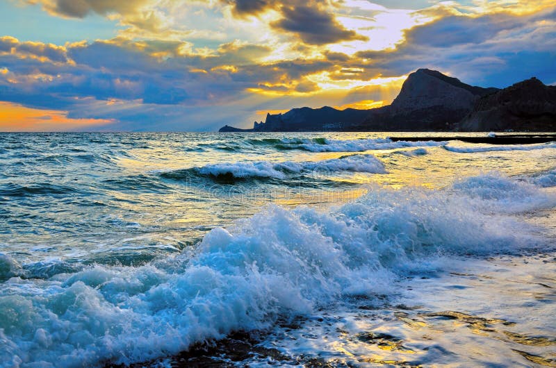 Sea wave on the beach, the surf on the Black sea coast at sunset.