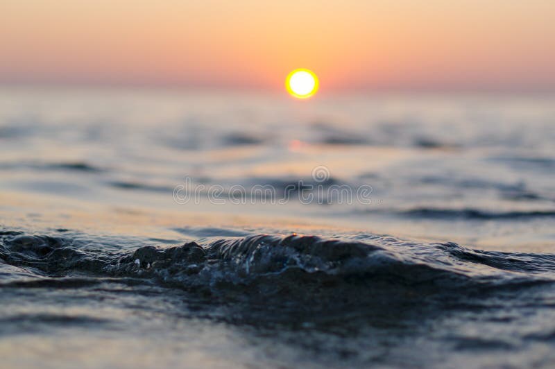 Sea wave close up at sunset time with red and orange sun reflection on the water. nature abstract blurred background. Phuket