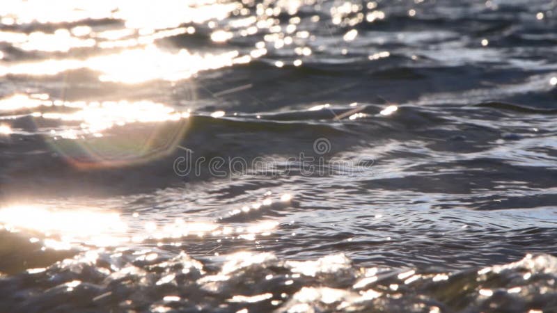 The sea wave runs over the sandy beach, shimmering in the rays of sunlight. Endless water space. stock video footage