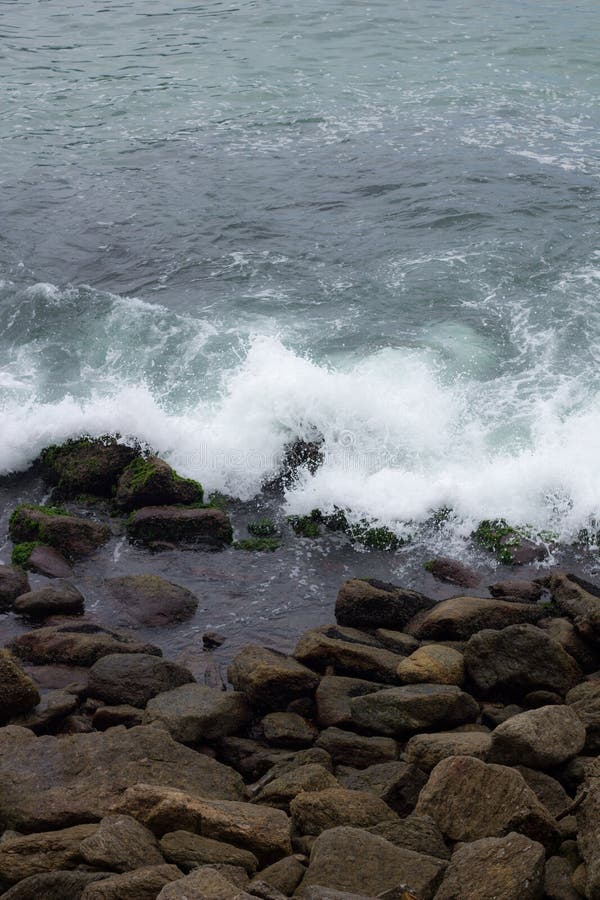 Sea waves crashing on rocks at the edge of the beach of arpoador stock photos Sea waves crashing on rocks at the edge of the beach of arpoador stock photos