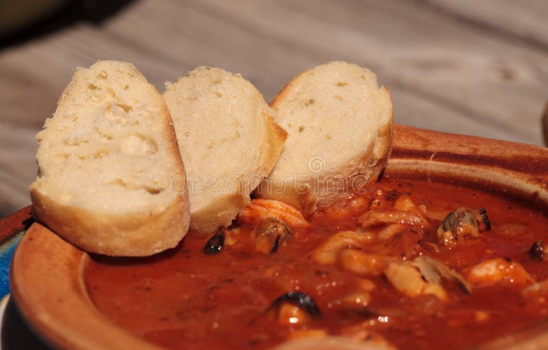 Seafood cioppino with French bread. Tomato, cutting.