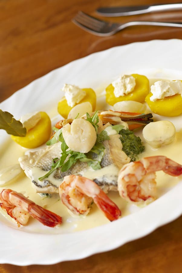 Seafood dish with spinach, potatoes and cream sauce royalty free stock photos