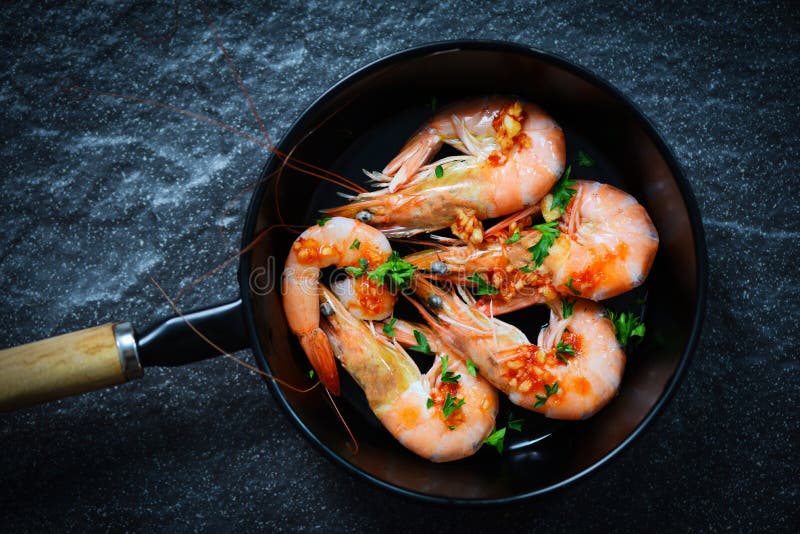 Seafood plate with shrimps prawns ocean gourmet dinner cooked with sauce herbs and spices on pan background / Close up shellfish shrimp boiled. Seafood plate with shrimps prawns ocean gourmet dinner cooked with sauce herbs and spices on pan background / Close up shellfish shrimp boiled