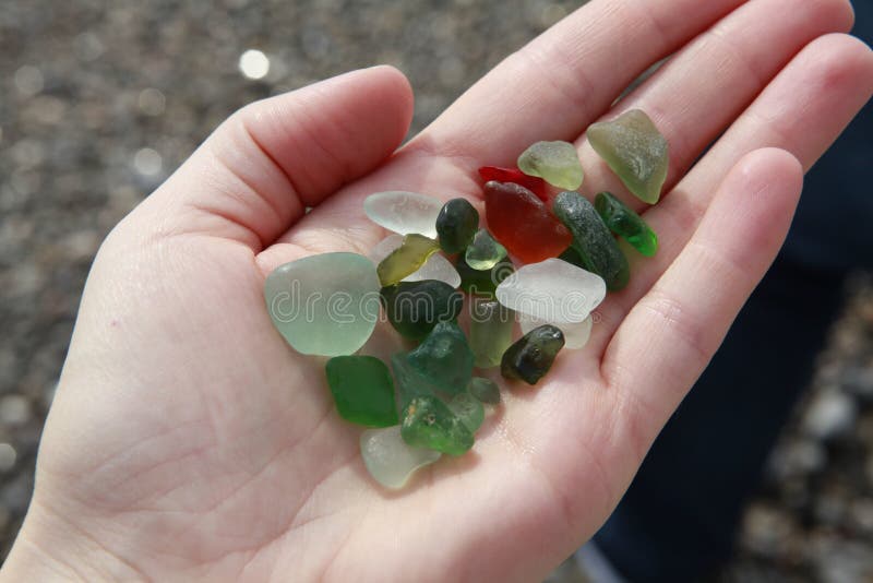 Seaglass verdi, marroni, bianchi nella mano fotografia stock