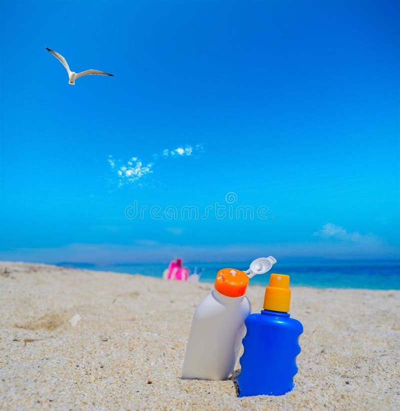 Seagull flying over the suntan lotion bottles stock images