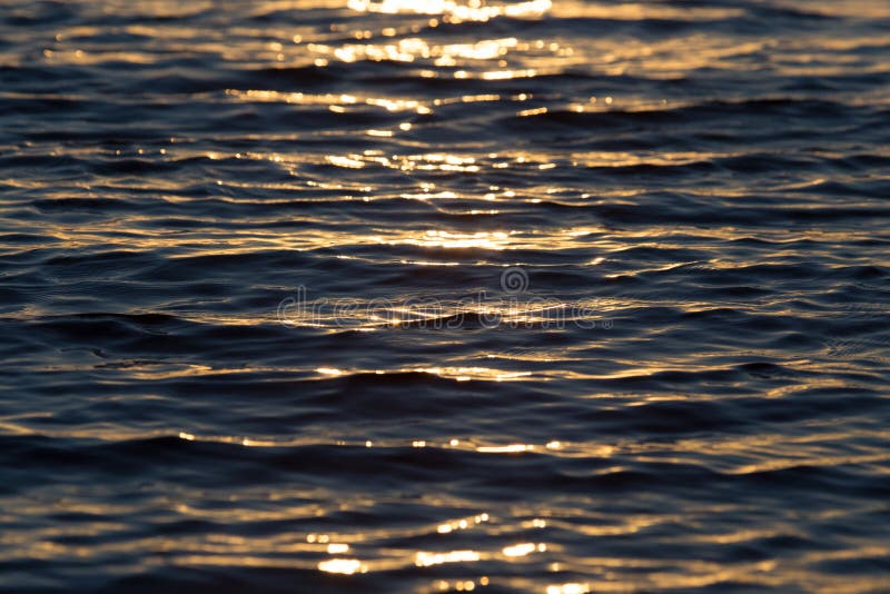 Seamless texture warm color shining sunset water surface. Closeup, nature.
