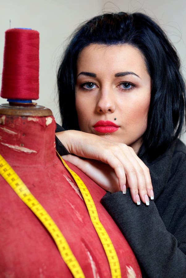 Seamstress with red old mannequin