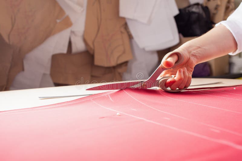 A Seamstress Woman Cuts Off the Excess Red Fabric Stock Image - Image ...