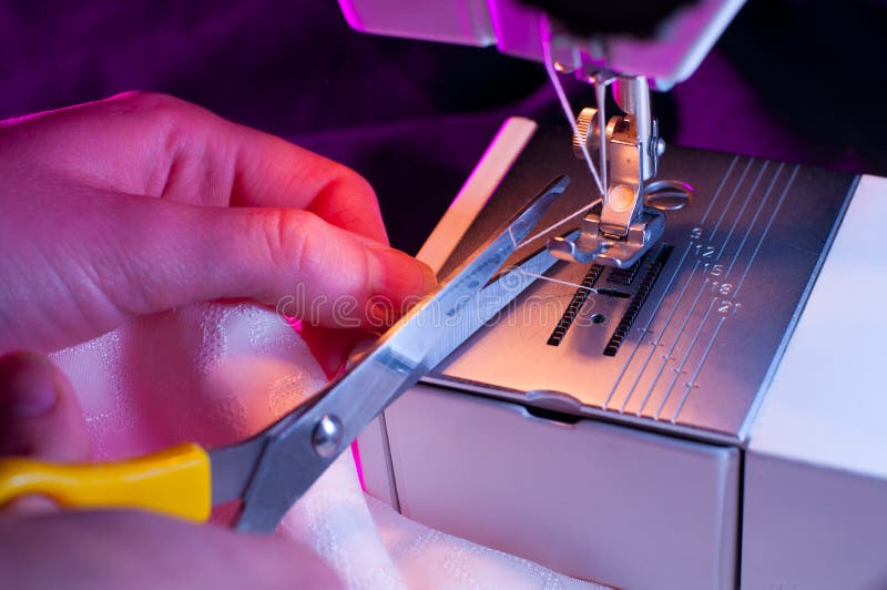 Seamstress που κόβει ένα νήμα μετά από να ράψει στοκ φωτογραφίες με δικαίωμα ελεύθερης χρήσης Seamstress που κόβει ένα νήμα μετά από να ράψει στοκ φωτογραφίες με δικαίωμα ελεύθερης χρήσης