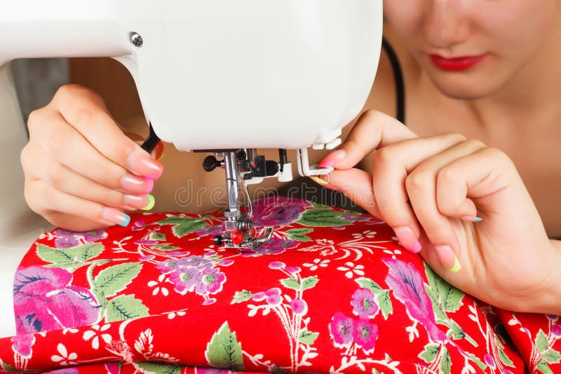 Seamstress ράβει το ύφασμα στη ράβοντας μηχανή στοκ φωτογραφία με δικαίωμα ελεύθερης χρήσης Seamstress ράβει το ύφασμα στη ράβοντας μηχανή στοκ φωτογραφία με δικαίωμα ελεύθερης χρήσης