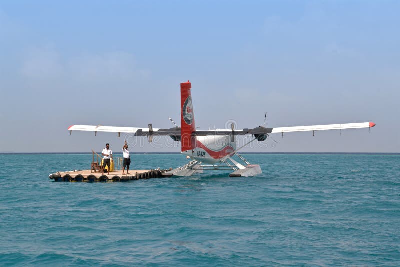 Male, Maldives - February 1, 2016: After seaplane drop passengers off at the floating platform, pilot and crews are waving at the passengers who are leaving on the boat to the island. Male, Maldives - February 1, 2016: After seaplane drop passengers off at the floating platform, pilot and crews are waving at the passengers who are leaving on the boat to the island.