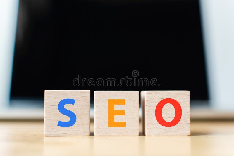 Wooden block cube shape with word SEO and laptop royalty free stock photos