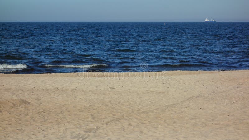 Seascape from the beach with a lone freighter on the horizon