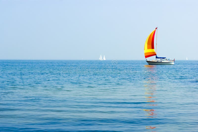 Seascape with sailboat at background of the blue sky.