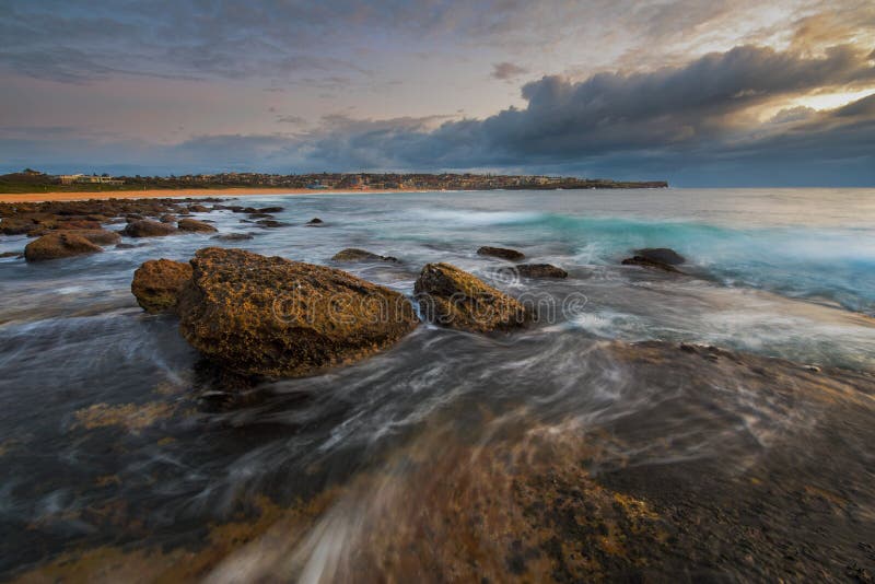 Seascape восхода солнца при большой утес и вода пропуская вокруг ее стоковое изображение rf Seascape восхода солнца при большой утес и вода пропуская вокруг ее стоковое изображение rf