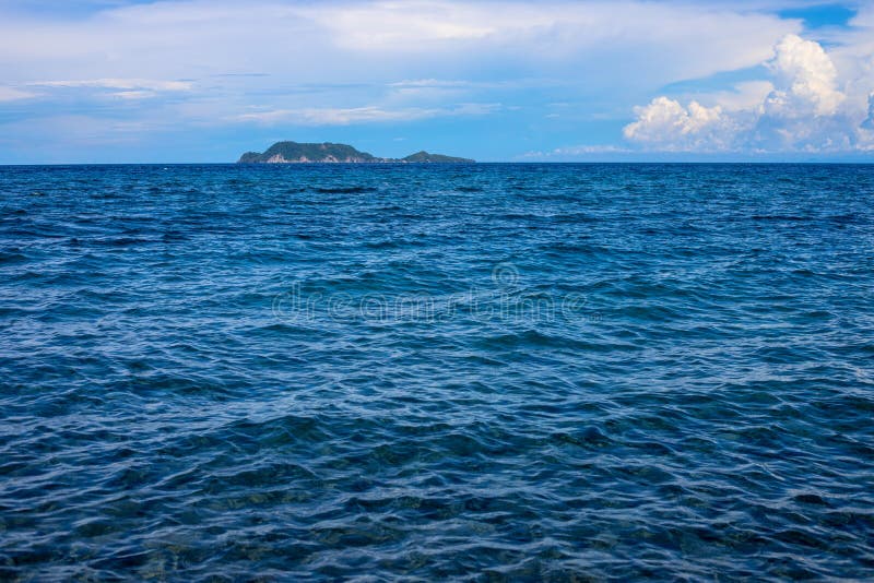 Seaside landscape with water surface and distant island. Sunny sea and sky landscape. Idyllic tropical scene. With green island photo background. Philippines stock image Seaside landscape with water surface and distant island. Sunny sea and sky landscape. Idyllic tropical scene. With green island photo background. Philippines stock image