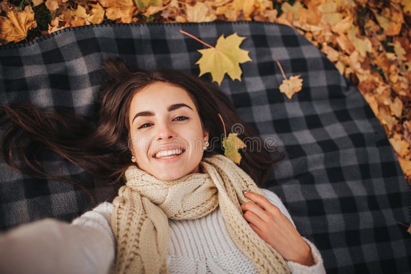 Season, technology and people concept - beautiful young woman lying on ground and autumn leaves and taking selfie with stock images Season, technology and people concept - beautiful young woman lying on ground and autumn leaves and taking selfie with stock images