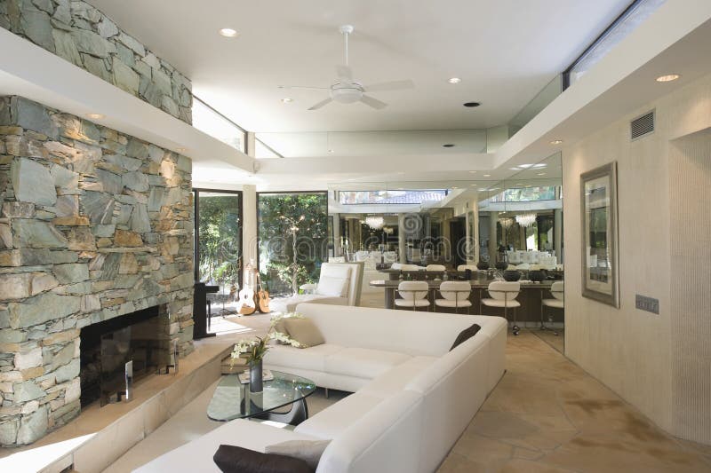 Seating Area And Stone Fireplace With Dining Area In Background