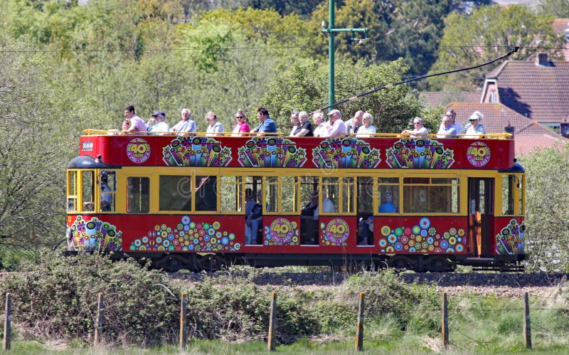SEATON, DEVON, ANGLETERRE - 22 MAI 2012 : Voyages rouges décorés d'un tram le long de la tramway de Seaton sur son chemin à Colyf photos libres de droits SEATON, DEVON, ANGLETERRE - 22 MAI 2012 : Voyages rouges décorés d'un tram le long de la tramway de Seaton sur son chemin à Colyf photos libres de droits