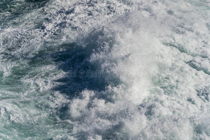 Seawater from a Wave As it Breaks Against a Rock, Sea Foam Stock Photo