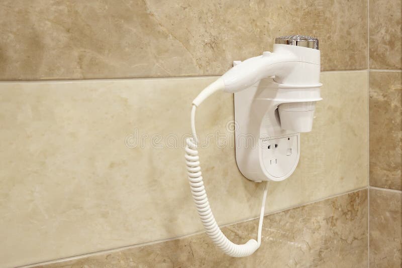Secador de pelo que cuelga en la pared en cuarto de baño de un hotel fotos de archivo Secador de pelo que cuelga en la pared en cuarto de baño de un hotel fotos de archivo