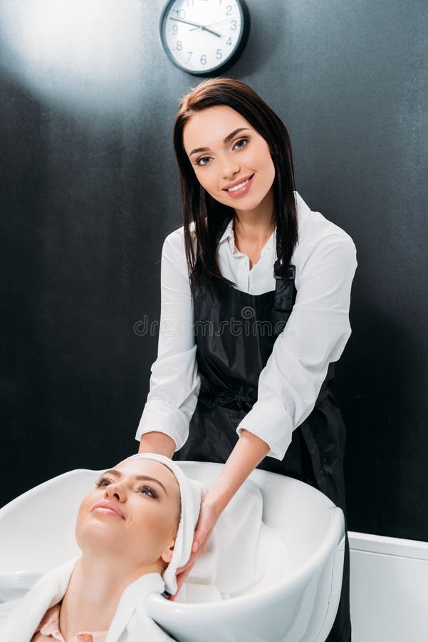 a secagem de sorriso do cabeleireiro lavou o cabelo do cliente com toalha e vista foto de stock a secagem de sorriso do cabeleireiro lavou o cabelo do cliente com toalha e vista foto de stock