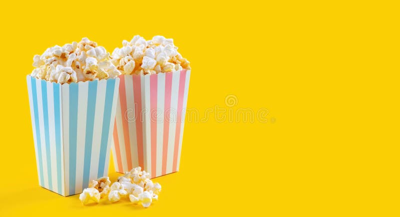 Secchio di cartone rosa a strisce blu con popcorn di formaggio gustoso isolato su fondo giallo immagine stock libera da diritti