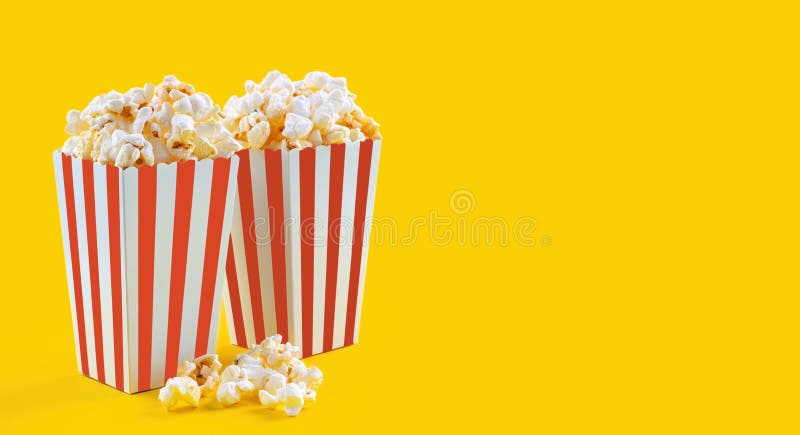 Secchio di cartone a strisce bianche rosso con popcorn al formaggio saporito isolato su fondo giallo immagine stock