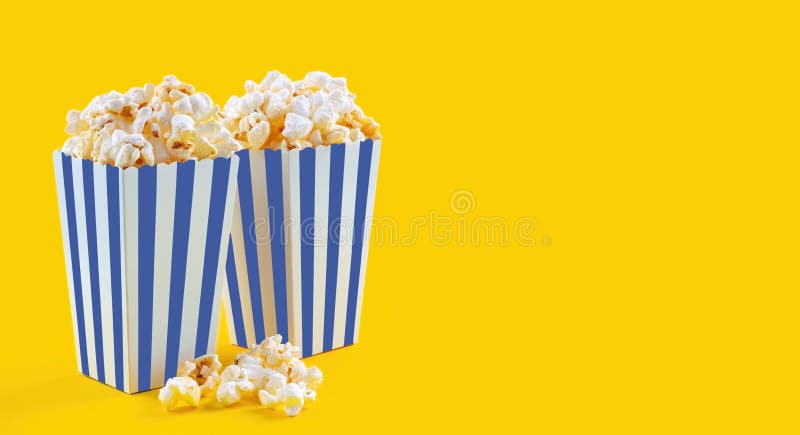 Secchio di cartone a strisce blu con popcorn di formaggio saporito isolato su fondo giallo fotografie stock