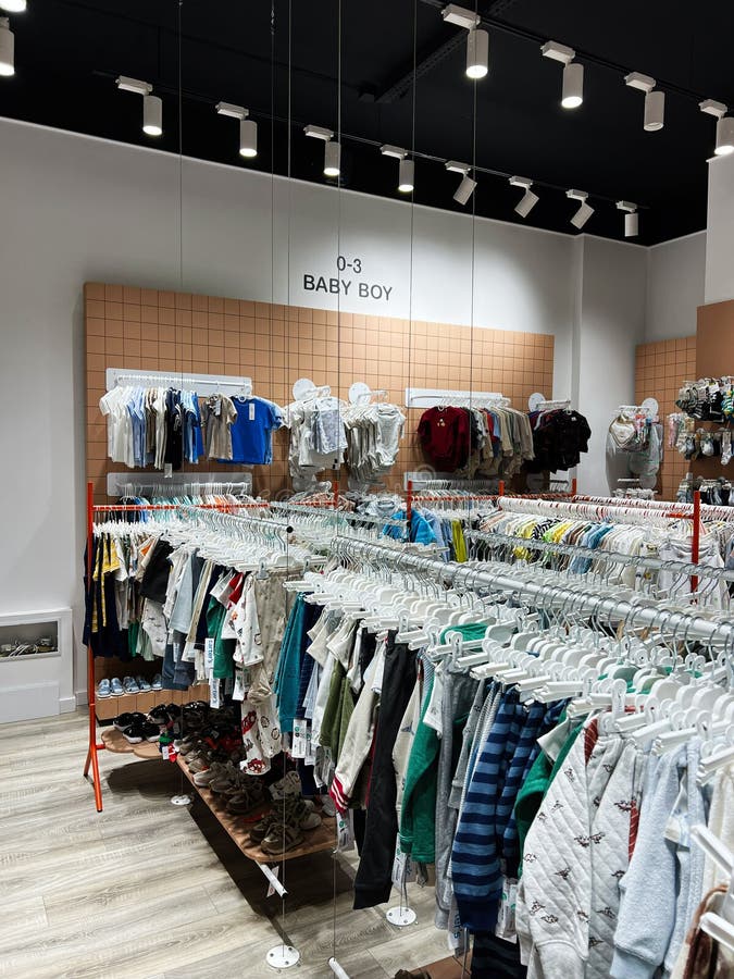 Sección de ropa para niños en una tienda minorista moderna con exhibiciones organizadas fotos de archivo