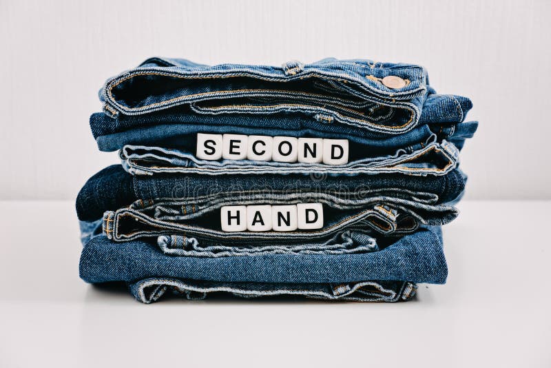 Second hand, Vintage Shopping, slow fashion, Sustainable fashion concept. Stack of blue old denim jeans with the words