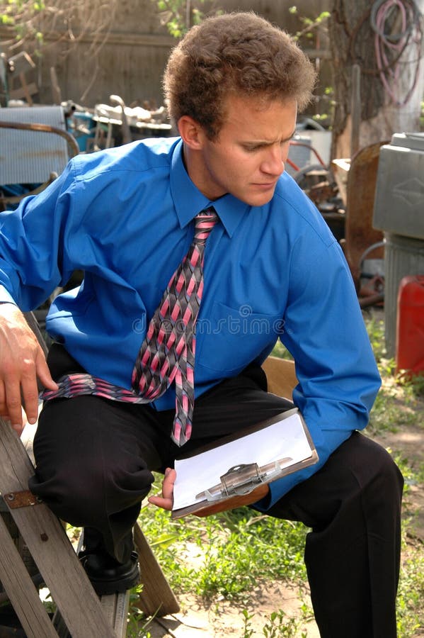 A man with a clipboard surveying the aftermath of a disaster. A man with a clipboard surveying the aftermath of a disaster