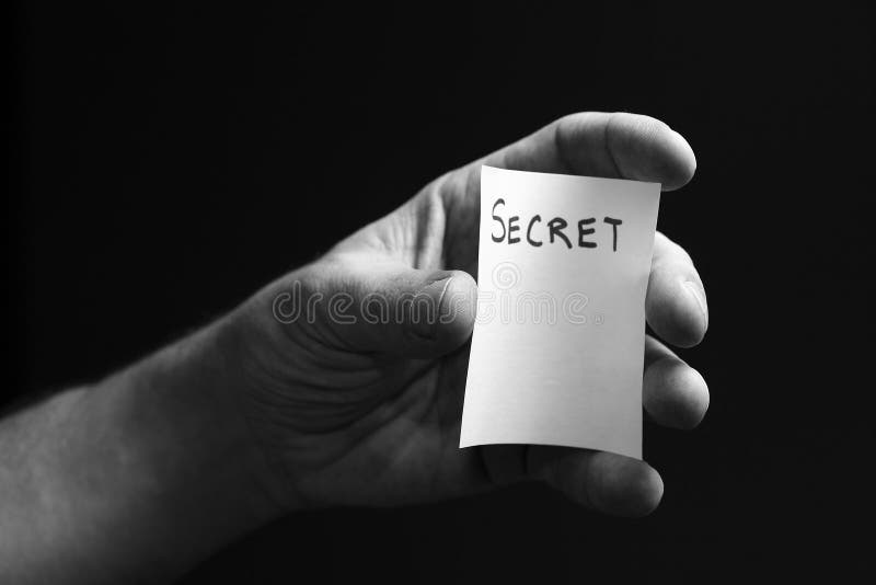 A hand protecting a secret. The word secret printed on a card. A hand protecting a secret. The word secret printed on a card.