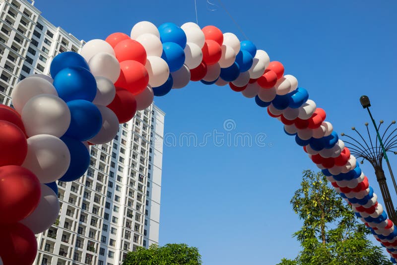 Secuencia de globos coloridos contra construcciones de viviendas y del cielo azul en fondo Concepto de actividades de la celebrac fotos de archivo Secuencia de globos coloridos contra construcciones de viviendas y del cielo azul en fondo Concepto de actividades de la celebrac fotos de archivo