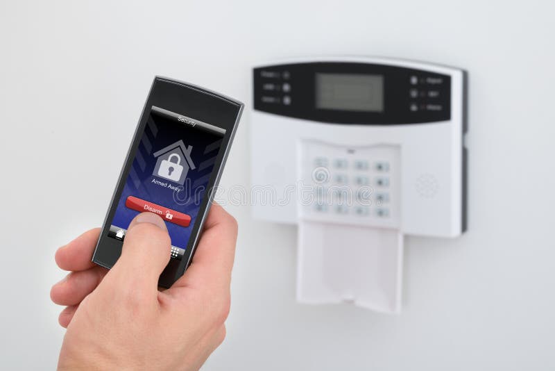 Security alarm keypad with person disarming the system royalty free stock photography