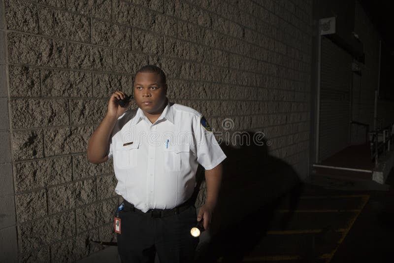 Security Guard With Walkie Talkie And Torch Patrols At Night royalty free stock photos