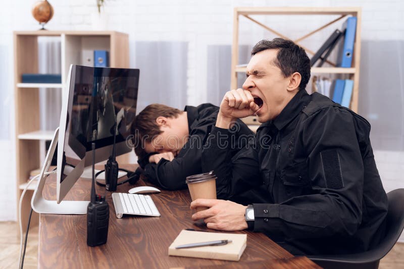 The security guard who sits in front of the monitor yawns. stock photos.