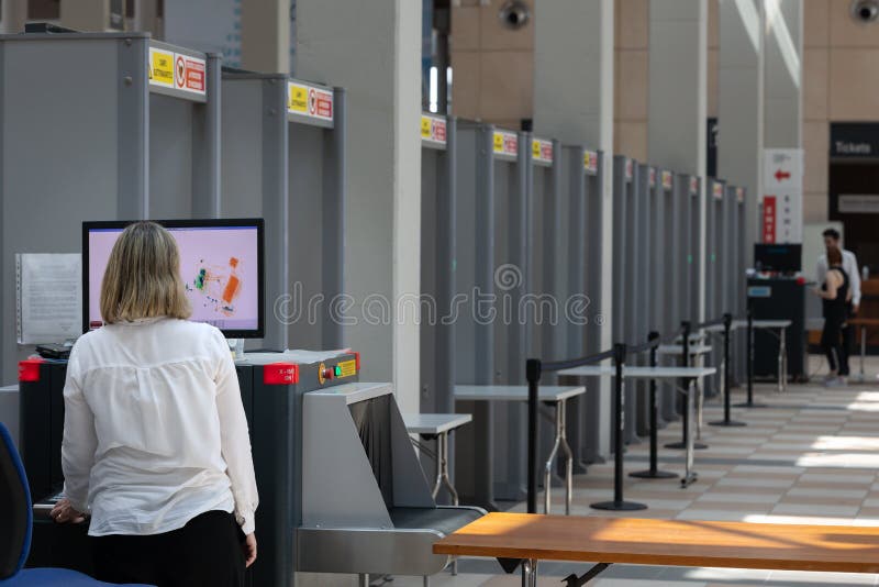 Security Personnel Checking Bags and Backpacks Xrayed at the Access