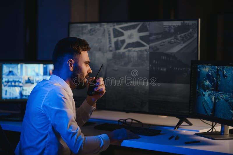 Security System CCTV Monitor Room. Man Using Walkie Talkie stock photo