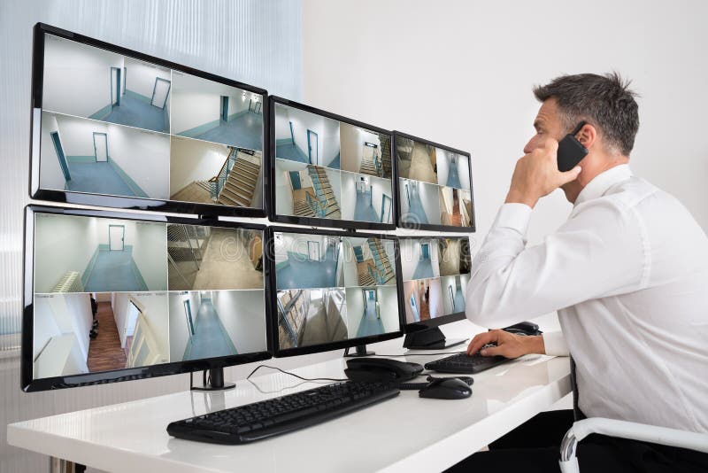 Security System Operator Looking At CCTV Footage royalty free stock image