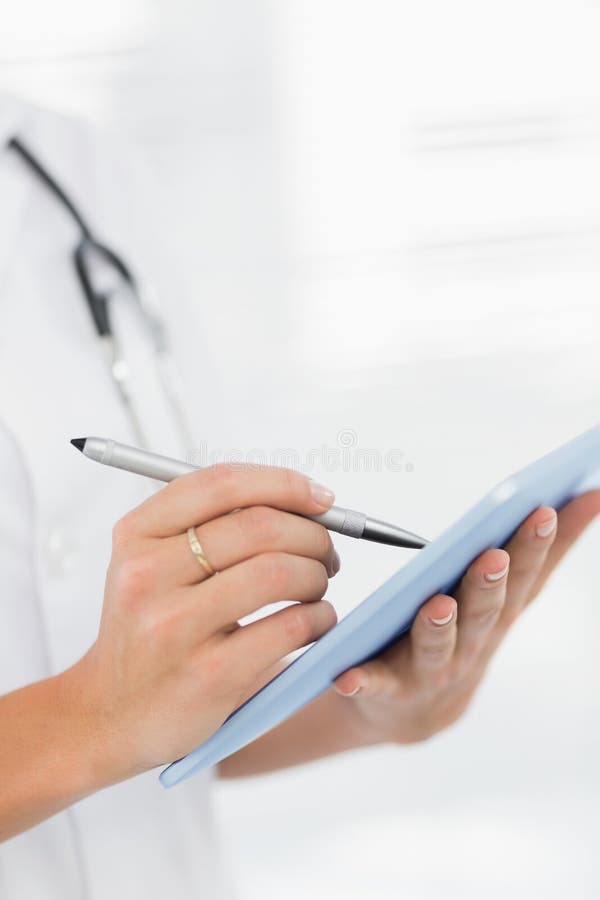 Secțiunea mediană a unui medic feminin care utilizează tabletă digitală stock image