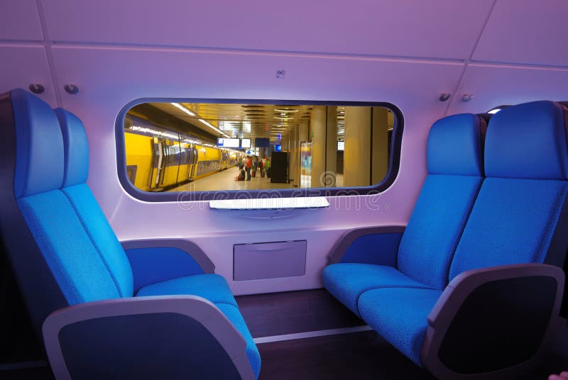 View of interior of a train, blue seats. through the window the underground station. View of interior of a train, blue seats. through the window the underground station
