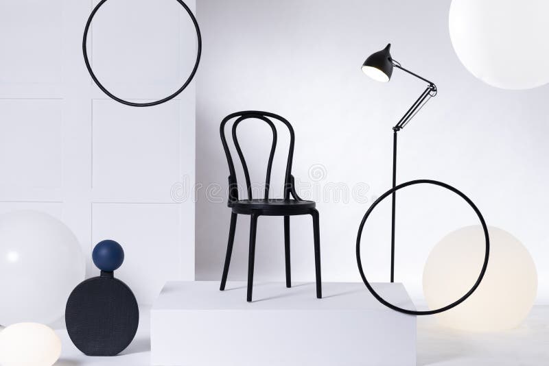 Sedia di legno nera sulla piattaforma bianca nell'interno in bianco e nero astratto immagine stock