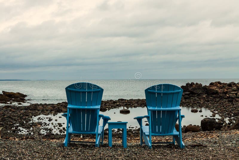 Sedie di legno blu su Rocky Beach fotografia stock Sedie di legno blu su Rocky Beach fotografia stock