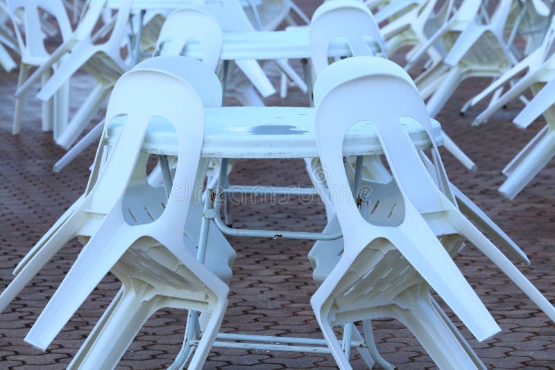 A picnic area with white plastic tables and chairs - abandoned on a rainy day. A picnic area with white plastic tables and chairs - abandoned on a rainy day