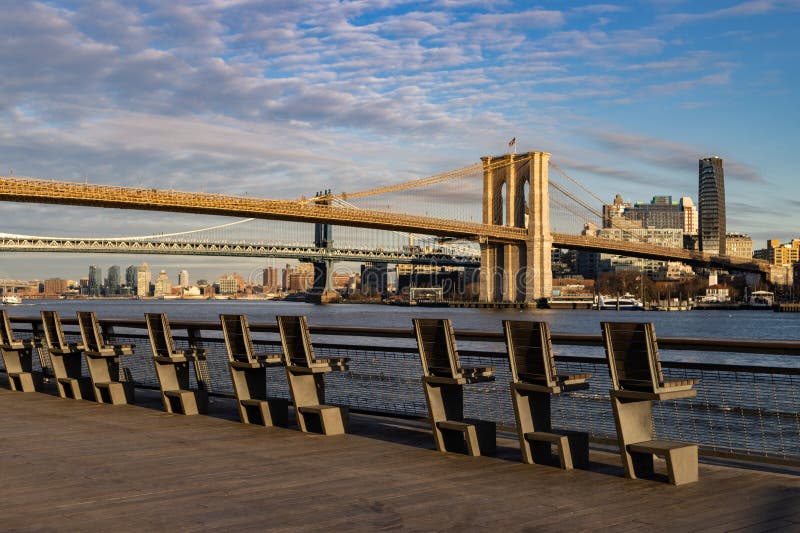 A row of empty chairs along the East River riverfront with a beautiful view of the Brooklyn Bridge at the South Street Seaport in New York City on February 4 2023. A row of empty chairs along the East River riverfront with a beautiful view of the Brooklyn Bridge at the South Street Seaport in New York City on February 4 2023.