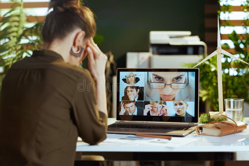 Seen from behind modern woman with laptop having video chat stock photography